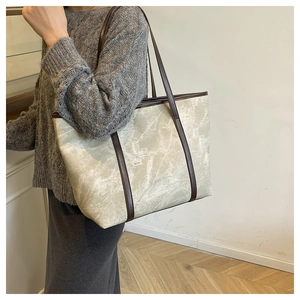 Detailed shoulder view of a large marble texture tote bag with brown leather straps