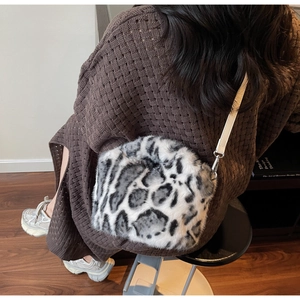 Detail der flauschigen Leopard-Beuteltasche mit cremefarbenem Gurt und Metallhaken