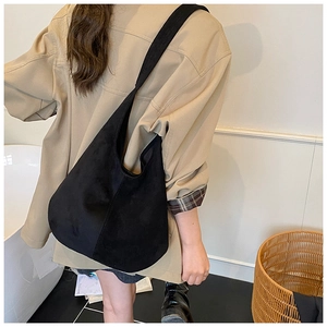 Vue arrière d'un mannequin portant un grand sac à épaule en daim noir de style décontracté