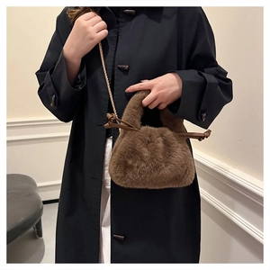 Detail der braunen Plüschtasche mit goldener Kette und ledernem Kordelzug-Knoten-Design