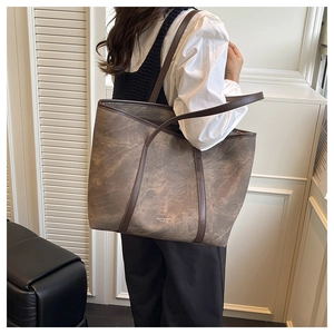 Detail of vintage marble textured tote bag with dark brown trim and slim shoulder straps