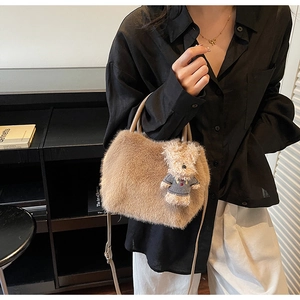 Detailansicht der khakifarbenen Plüschhandtasche mit Teddybär-Anhänger und Lederriemen