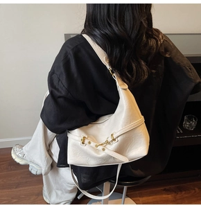 Dettaglio della borsa hobo beige in pelle martellata con fibbia metallica elegante