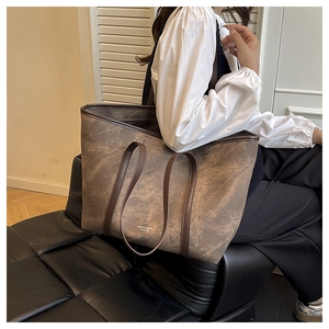 Detail of vintage marble textured brown tote bag shown on a model in a casual setting