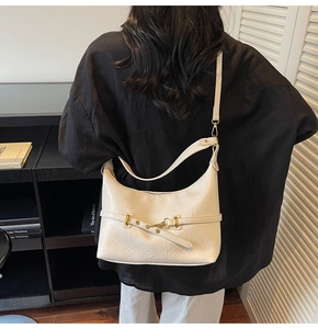 Dettaglio della borsa hobo retrò crema con tracolla regolabile e fibbia in metallo bronzo