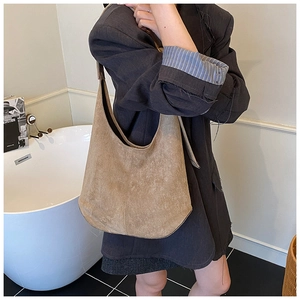 Sac hobo en daim marron porté à l'épaule, cabas minimaliste surdimensionné au look vintage