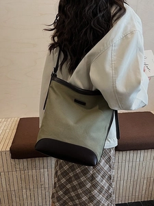 Minimalist canvas bucket shoulder bag in army green and dark brown leather for daily commute