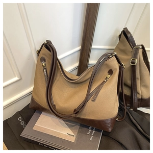 Detail of vintage canvas bucket bag with brown leather trim and side zipper pocket