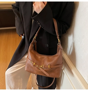 Dettaglio della borsa hobo marrone vintage con morsetto metallico e trama in finta pelle