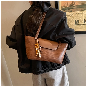 Dettaglio borsa vintage marrone testurizzata con decorazione di perline in legno etnico