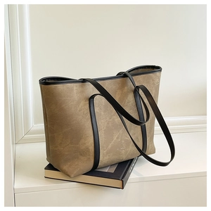 Detail of retro marbled leather tote bag with black handles and gold logo on books