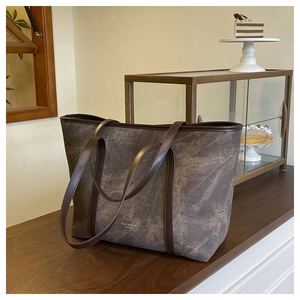 Detail of vintage marble textured tote bag with leather handles in a cafe setting