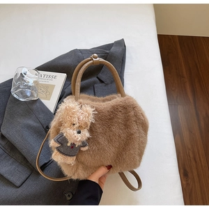 Detail der braunen Plüschtasche mit Bärenanhänger und Ledergriffen in schickem Setting