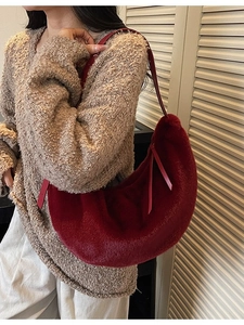 Fuzzy dark red faux fur crescent shoulder bag with slim leather straps on model