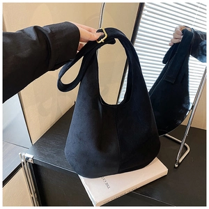 Détail du sac hobo en daim noir avec texture premium et boucle de réglage en métal doré