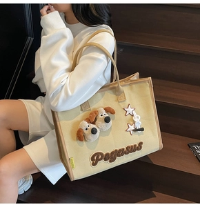 Détail du cabas en toile avec patchs chiots en peluche et broderie Pegasus