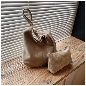 Détail de l'ensemble sac seau en daim avec bandoulière large et petite pochette assortie
