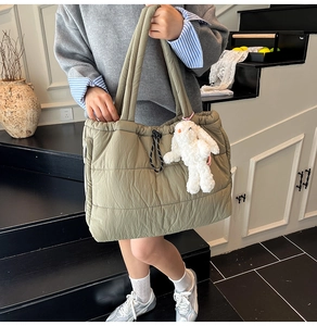 Quilted puffer tote bag in olive green with drawstring closure and rabbit charm