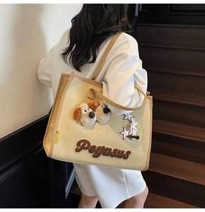 Détail du cabas en toile avec chiens en peluche 3D et broderie Pegasus porté par mannequin