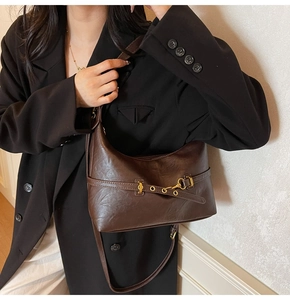 Dettaglio borsa hobo marrone vintage su modella con blazer nero stile retrò