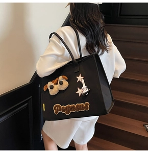 Détail du cabas en toile noire avec icônes de chiots en peluche et broderie Pegasus