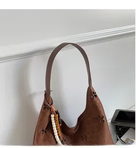Détail du sac cabas marron foncé à motif léopard avec fleurs découpées et breloque perlée