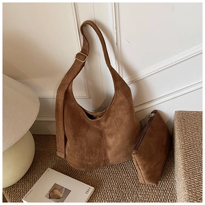 Gros plan du sac hobo en daim marron avec pochette assortie et détails de boucle dorée