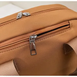Detail of premium brown canvas bag featuring smooth double metal zippers and woven handles