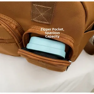 Detail view of large brown canvas tote bag featuring front zipper pocket and ample storage