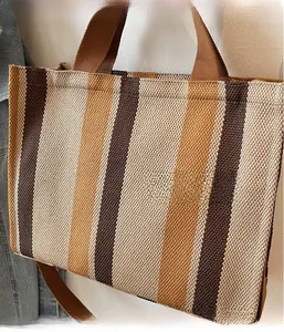 Detail of the vertical striped texture and durable woven handles on this canvas tote bag