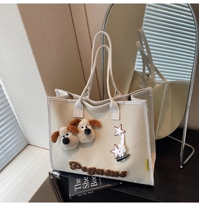 Détail du sac cabas en toile avec têtes de chiots en peluche et broderie en chenille