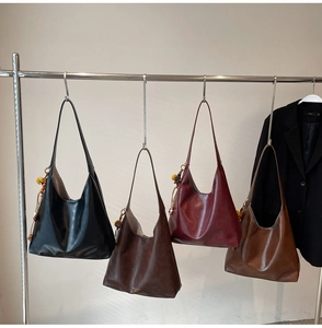 Detail showing matte leather tote bags in four colors with wooden bead tassels