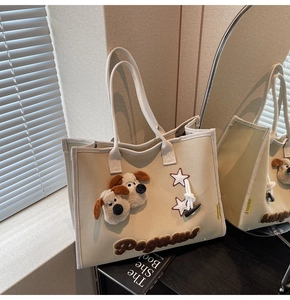 Détail du sac cabas en toile avec décor 3D de chiots en peluche et broderie sous lumière naturelle