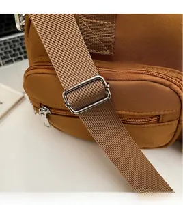 Detail of adjustable woven shoulder strap and metal buckle on brown casual tote bag