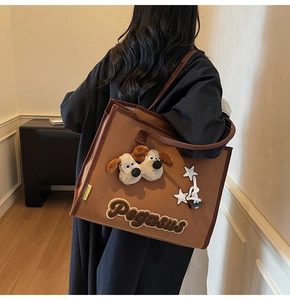 Détails des motifs chiots en peluche et broderie Pegasus sur grand sac cabas marron