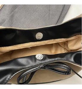Close-up of magnetic snap closure and black bow detail on leopard tote bag
