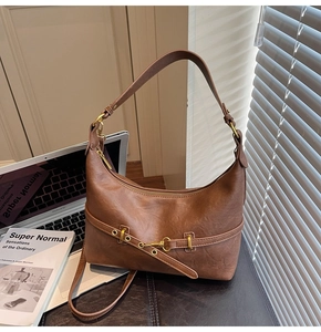 Dettaglio borsa hobo marrone vintage con finiture dorate e texture in pelle pieghettata