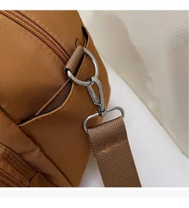 Detail of premium caramel nylon bag featuring high-quality metal D-ring and lobster clasp