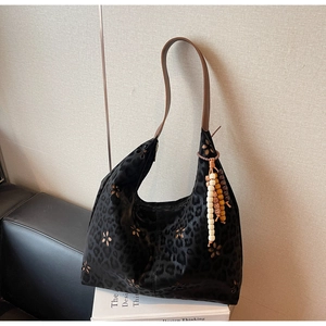 Détails du cabas léopard noir avec motifs évidés et pendentifs en perles de bois