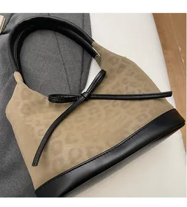 Detail of leopard print tote bag featuring black leather strap and bow decoration