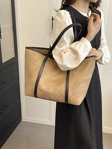 Brown textured leather tote bag for women showing a stylish shoulder carry on a model