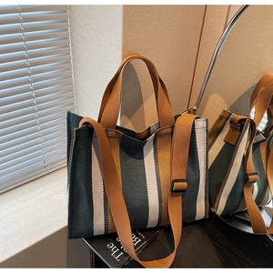 Detail of striped canvas tote showing adjustable wide strap and woven texture fabric