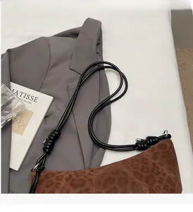 Detail of leopard print hobo bag with matte texture and decorative knotted rope handle