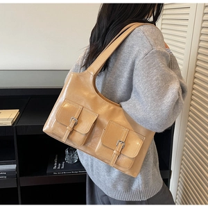Detail showing vintage tan faux leather shoulder bag with dual front buckle pockets
