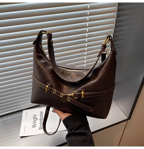 Dettaglio della borsa hobo vintage marrone scuro con trama in pelle e hardware dorato