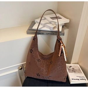 Détails macro d'un sac cabas marron léopard avec découpes fleurs et breloque en bois