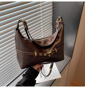 Dettaglio della borsa sottobraccio in pelle stropicciata marrone con fibbia dorata