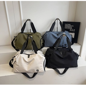 Macro shot of large travel bags in four colors on a white display with logo detail