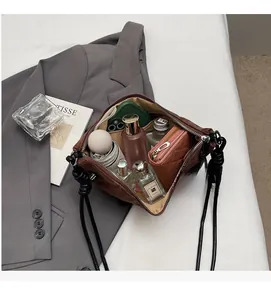 Detail showing spacious interior of brown quilted crossbody bag with daily essentials