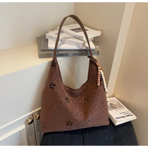 Détail du cabas marron foncé à imprimé léopard avec motif floral découpé au laser